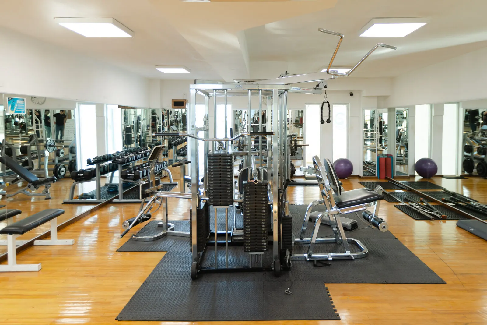 Área de gym de TYM con aparatos y pesas